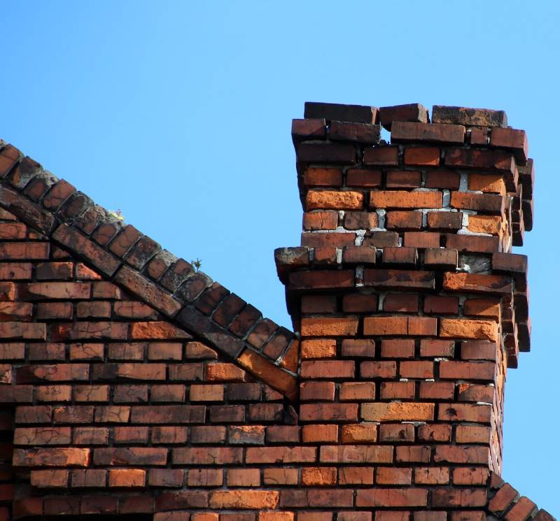Signs Your Frisco Home Needs a Chimney Inspection Blog Article - Damaged chimney on an Frisco home showing cracks and missing mortar